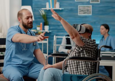 Retired woman using vr glasses nurse assisting