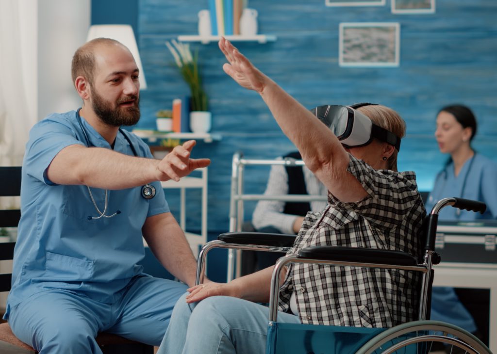 Retired woman using vr glasses nurse assisting